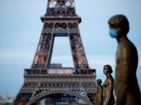 Golden Statues at the Trocadero square near the Eiffel tower wear protective masks during the outbreak of COVID-19, in Paris on May 2.