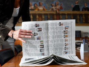Journalist Daniela Taiocchi leafs through the May 12, 2020 edition of Italian newspaper L'Eco di Bergamo which featured 10 pages of obituaries due to the high number of deaths from COVID-19, in Bergamo, Italy.