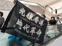 A pro-democracy supporter holds a Liberate Hong Kong. Revolution of Our Time flag during a rally at a shopping mall on May 25, 2020 in Hong Kong.