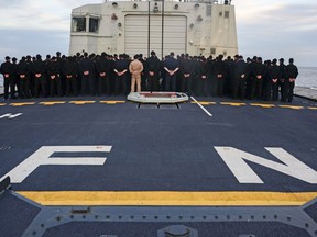 Crew members aboard HMCS Fredericton pay their respects to the fallen during the vigil for the deceased members of the CH-148 Cyclone accident, in the Mediterranean Sea on May 1, 2020.