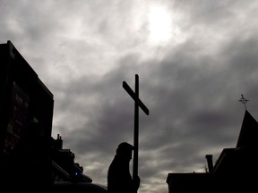 The faithful walk through the streets of old Montreal during the stations of the cross on Good Friday in Montreal, Friday, March 29, 2013. In Quebec, where the Catholic Church historically played a central role in society but has in recent years struggled with low attendance and a lack of revenue, closures have made an already difficult situation worse.