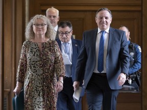 Quebec Minister Responsible for Seniors and Informal Caregivers Marguerite Blais, left, Quebec Premier Francois Legault, right, and Horacio Arruda, Quebec director of National Public Health, centre, walk to a news conference on the COVID-19 pandemic, Tuesday, May 5, 2020 at the legislature in Quebec City.