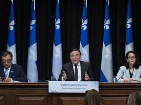 Quebec Premier Francois Legault speaks during a news conference on the COVID-19 pandemic, Thursday, May 28, 2020 at the legislature in Quebec City. Legault is flanked by Horacio Arruda, Quebec director of National Public Health, left, and Quebec Justice Minister and Minister Responsible for Canadian Relations and the Canadian Francophonie Sonia Lebel.