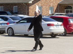 Pastor Henry Hildebrandt of the Church of God in Aylmer walks among his churchgoers, all seated in their vehicles. Photograph taken on Sunday May 3, 2020. Mike Hensen/The London Free Press/Postmedia Network