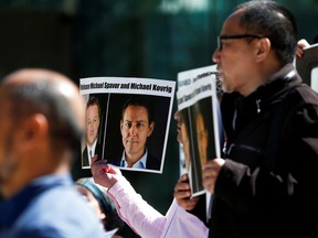 People hold signs calling for China to release Canadian detainees Michael Spavor and Michael Kovrig during a court appearance by Huawei's financial chief, Meng Wanzhou, outside the B.C. Supreme Court building in Vancouver on May 8, 2019.