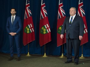Ontario Premier Doug Ford, right, and Ontario Minister of Education Stephen Lecce physical distance during daily updates regarding COVID-19 at Queen's Park in Toronto on Wednesday, May 13, 2020.