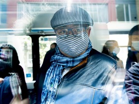 Dr. Horacio Arruda, Quebec's director of public health, wearing a protective mask, peers through the window of a mobile clinic, in Montreal, on Friday, May 8, 2020.