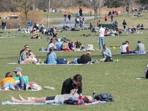 People enjoy a warm day in a park in Montreal, Saturday, May 2, 2020, as the COVID-19 pandemic continues in Canada and around the world.