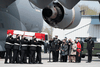 Family members watch as masked pallbearers carry the casket of Sub-Lt. Abbigail Cowbrough during a repatriation ceremony at CFB Trenton for the six Canadian Forces personnel killed in a helicopter crash off the coast of Greece, May 6, 2020.