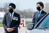 National Defence Minister Harjit Sajjan and Prime Minister Justin Trudeau, wearing protective face masks, attend a repatriation ceremony at CFB Trenton for the six Canadian Forces personnel killed in a helicopter crash off the coast of Greece, May 6, 2020.