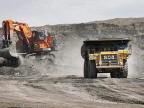 A haul truck carrying a full load drives away from a mining shovel at the Shell Albian Sands oilsands mine near Fort McMurray, Alta., Wednesday, July 9, 2008. Alberta's Energy Regulator has suspended a wide array of environmental monitoring requirements for companies in the oilsands.