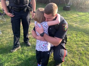 Const. Michael Norrie with the Prince Albert Police Service gets a warm hug from Kendra in Prince Albert, Sask. on Tuesday, May 19, 2020. Kendra, a five-year-old girl who survived when her paternal grandparents and brother died in a triple slaying in Saskatchewan, came home to a welcome that astonished and delighted her.THE CANADIAN PRESS/HO-Nigel Maxwell, paNOW MANDATORY CREDIT