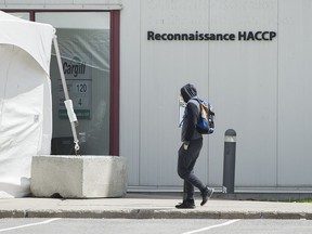 A man walks into a Cargill meat processing plant in Chambly, Que., south of Montreal, Sunday, May 10, 2020. A group representing Canada's meat-packing industry is expecting more changes in the coming months to make sure workers have protection from the COVID-19 pandemic.