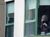 An elderly woman looks out from Maison Herron, a long term care home in the Montreal suburb of Dorval, during the COVID-19 pandemic.