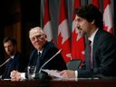 Der Minister für öffentliche Sicherheit Bill Blair (Mitte) hört zu, während Premierminister Justin Trudeau (rechts) während einer Pressekonferenz auf dem Parliament Hill in Ottawa am 1. Mai spricht.