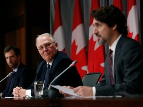 Public Safety Minister Bill Blair, centre, listens while Prime Minister Justin Trudeau, right, speaks during a news conference on Parliament Hill in Ottawa, on May 1.