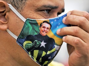 A supporter of President Jair Bolsonaro wears a face mask with Bolsonaro's image during a demonstration at Copacabana beach in Rio de Janeiro, Brazil, on June 7, 2020.