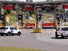 In this photo taken Sunday, May 17, 2020, a truck from Canada heads to the single open lane heading into the U.S. at the Peace Arch border crossing in Blaine, Wash.