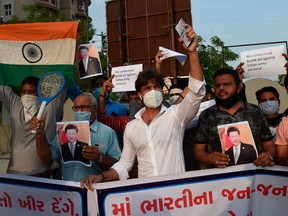 Members of the non-governmental organization MADADGAAR PARIVAR, hold placards and shout slogans as they protest against the killing of Indian soldiers by Chinese troops, in Ahmedabad on June 16, 2020.