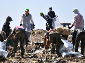 People work to search for belongings and  debris for forensic analysis at the  crash site of the Ethiopian Airlines operated Boeing 737 MAX aircraft in which their relatives perished among the 157 passengers and crew onboard, at Hama Quntushele village, near Bishoftu, in Oromia region, on March 15, 2019.