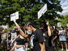 A protester wearing a mask and gloves to protect from COVID-19 participates in an anti-racism march in Toronto on June 6.