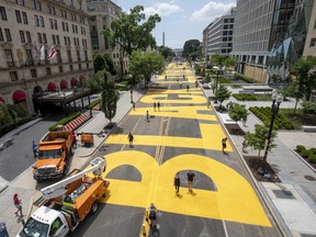 People walk down 16th street after volunteers, with permission from the city, painted "Black Lives Matter" on the street near the White House on June 05, 2020 in Washington, DC.