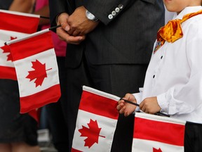 New Canadians sing the national anthem during a ceremony on Canada Day in Toronto in 2010.