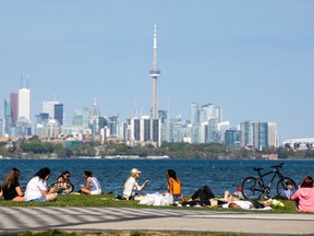 People maintain social distance as they sit at Humber Bay Shores park while the province prepares for more phased re-openings from the coronavirus disease (COVID-19) restrictions in Toronto, Ontario, May 24, 2020.