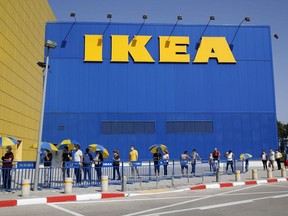 Customers maintain a safe distance from each other as they wait in line to enter an IKEA outlet in the Israeli coastal town of Netanya on April 22, 2020, after authorities eased down some restrictions.