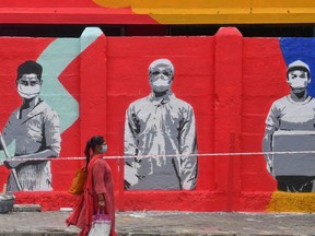 A pedestrian walks past a mural painted to thank frontline workers fighting against the spread of the COVID-19 coronavirus.