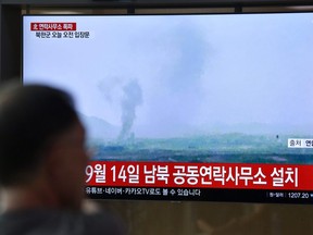 People watch a television news screen showing an explosion of an inter-Korean liaison office in North Korea's Kaesong Industrial Complex, at a railway station in Seoul on June 16, 2020.