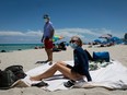 Diane, a nurse from Houston, Texas, sunbathes at the beach next to her husband, both wearing facemasks, in Miami Beach, Florida on June 16, 2020.