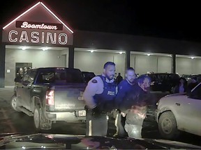 Chief Allan Adam of the Athabasca Chipewyan First Nation is walked to a police vehicle during his violent arrest by RCMP officers, in a still from police dashcam video obtained during legal discovery, in Fort McMurray, Alta., on March 10.