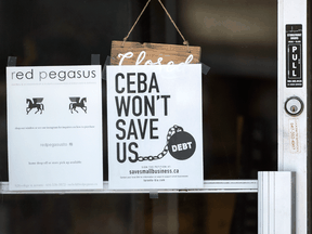 A sign on a Toronto business's door states 'CEBA won't save us' during the COVID-19 pandemic.