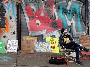 A demonstrator sits at the self-proclaimed Capitol Hill Autonomous Zone (CHAZ) during a protest against racial inequality and calls for the defunding of police, in Seattle, Wash., on June 15, 2020.