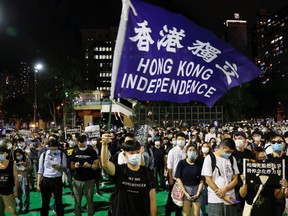 A person wearing a protective face mask waves a Hong Kong independence flag as protesters take part in a candlelight vigil to mark the 31st anniversary of the crackdown of pro-democracy protests at Beijing's Tiananmen Square in 1989, after police rejects a mass annual vigil on public health grounds, at Victoria Park, in Hong Kong, June 4, 2020.