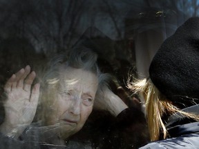A woman visits her 86-year-old mother through a window at the Orchard Villa long-term care home in Pickering, Ont., on April 22.
