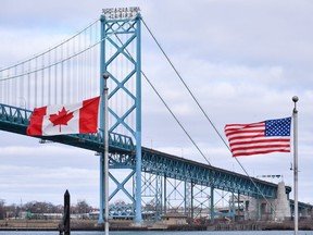 Canadian and American flags fly near the Ambassador Bridge at the Canada-USA border crossing in Windsor, Ont. on Saturday, March 21, 2020.