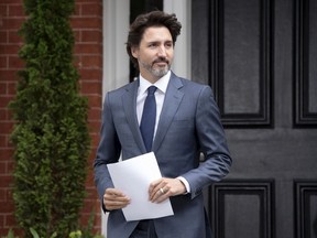Prime Minister Justin Trudeau makes his way to the podium for a news conference outside Rideau Cottage in Ottawa, Thursday, June 25, 2020.