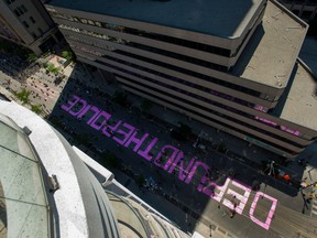 Thousands of people demonstrate to defund the police during a Black Lives Matter protest as they painted the street pink in front of the City of Toronto police headquarters in Toronto on Friday, June 19, 2020.