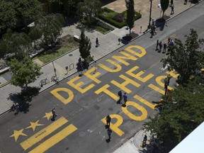 People walk down 16th street after Defund The Police was painted on the street near the White House on June 08, 2020 in Washington, DC.