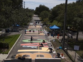 Local artists collaborate on painting a Black Lives Matter street mural in front of the Dr. Carter G. Woodson African American Museum, in St. Petersburg, Fla., on Thursday, June 18, 2020. Americans are gathering today to mark the anniversary of an emancipation that came two and a half years late -- liberty that many say feels like it never came at all.