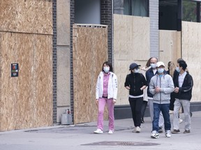 Shoppers walk past boarded up stores on Montreal's Sainte-Catherine street on Wednesday, June 3, 2020. Small and medium businesses in Montreal will receive $50 million in support from the provincial and federal government as they emerge from the COVID-19 crisis.