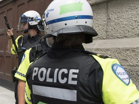 Police officers look on during demonstration calling for justice for the death of George Floyd and all victims of police brutality in Montreal on Sunday, June 7, 2020. An Ontario woman visiting Montreal last year says she was arrested, injured by police and then, hours later, sexually assaulted by an off-duty officer in her hotel room.