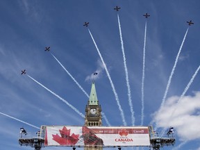 Royal Canadian Air Force Snowbirds fly past the Peace Tower during the Canada Day noon show on Parliament Hill in Ottawa on Monday, July 1, 2019. Federal officials are releasing the details of how July 1 will go down this year without the usual festivities on Parliament Hill acting as an anchor for cross-country parties.
