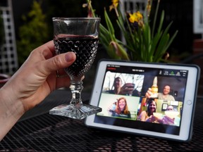 A woman lifts her glass and cheers with friends during a virtual happy hour amid the coronavirus crisis on April 8.