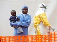 Mwamini Kahindo, an Ebola survivor working as a caregiver to babies who are confirmed Ebola cases, holds an infant outside the red zone at the Ebola treatment centre in Butembo, Democratic Republic of Congo, March 25, 2019.