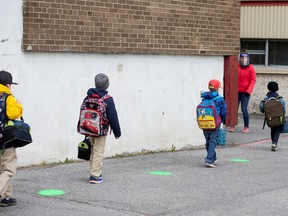 Green dots are placed in the schoolyard to help students keep distancing as schools outside the greater Montreal region begin to reopen their doors amid the coronavirus disease (COVID-19) outbreak, in Saint-Jean-sur-Richelieu, Quebec, Canada May 11, 2020.
