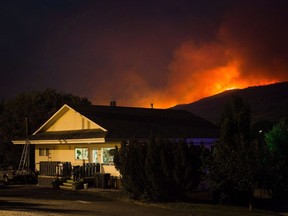 The federal government is investing $5 million in national wildfire research to try and close the gaps that have left fire prevention experts without the knowledge they need to keep Canada and its forests from burning. A wildfire burns on a mountain behind an RV park office in Cache Creek, B.C., Saturday July 8, 2017.