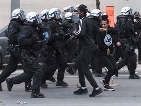 Police push back protesters during a demonstration calling for justice in the death of George Floyd and victims of police brutality in Montreal, Sunday, May 31, 2020.THE CANADIAN PRESS/Graham Hughes